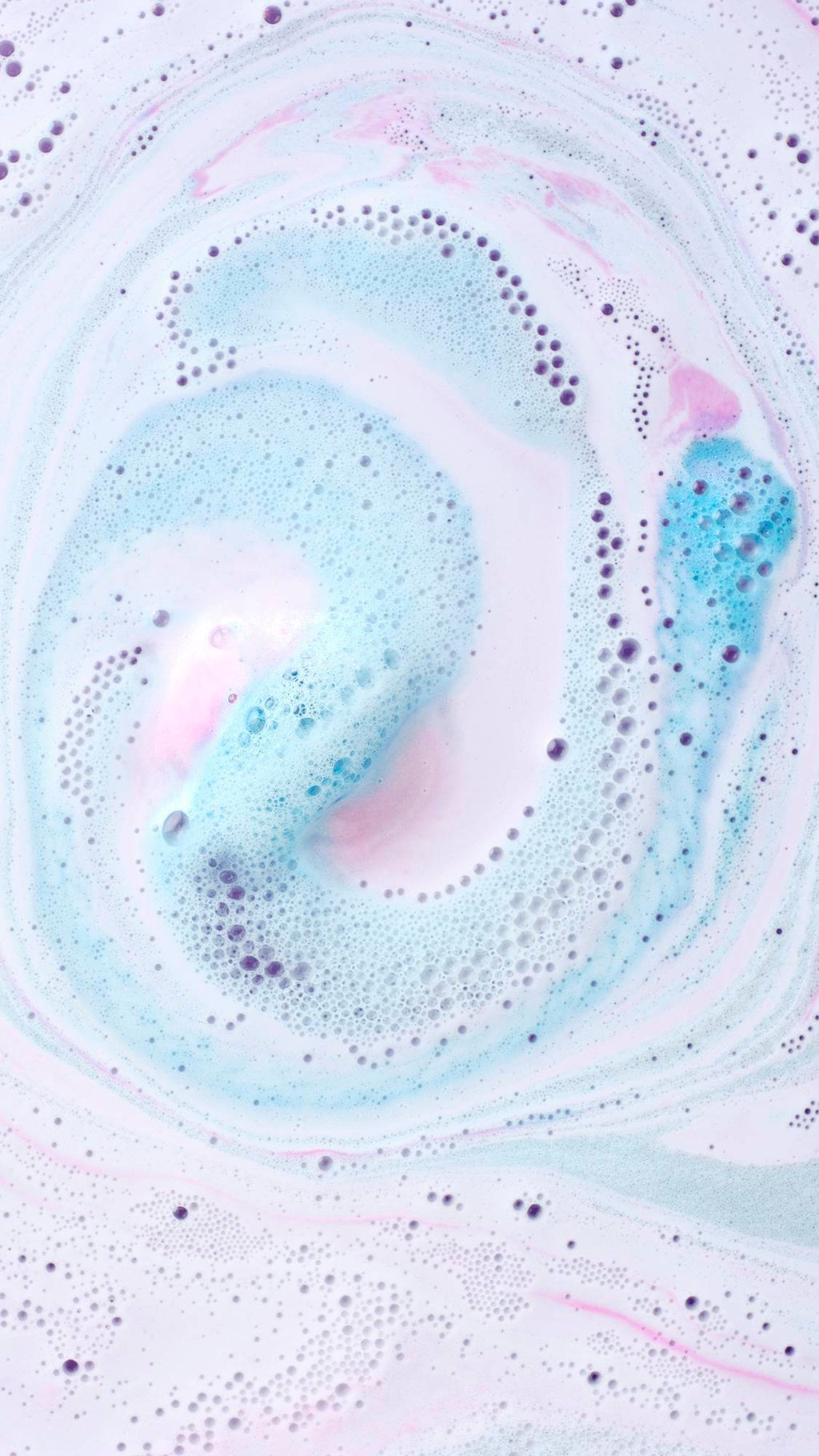 A top-down view of a dissolved Twilight Bath Bomb in water, showing a mesmerizing, milky swirl of pastel blue, lavender, and white foam with tiny bubbles.