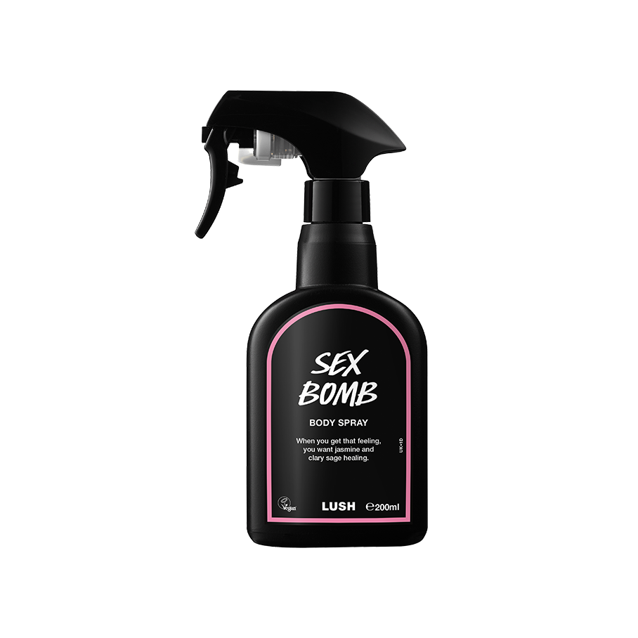 Sex Bomb body spray. A black spray bottle of Lush "Sex Bomb" Body Spray. The product label is black with a dusky pink banded border. White text states the product name and the scent description.