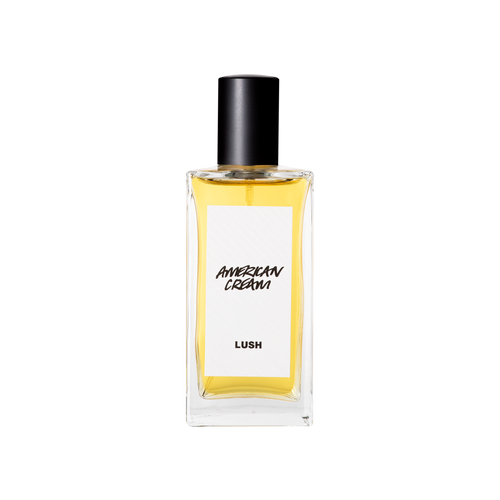 A glass perfume bottle filled with light amber liquid. A white label reads 'American Cream'.