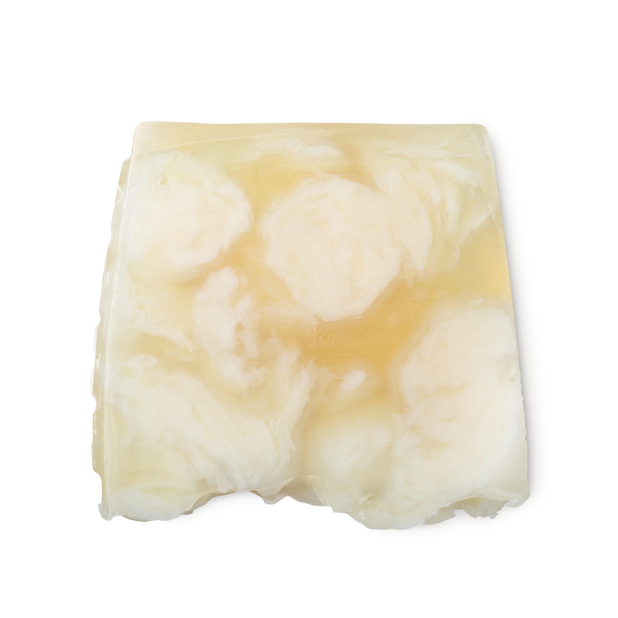 Bohemian. A light yellow, creamy swirled, smooth, trapezium shaped soap, with bumps along its left side.