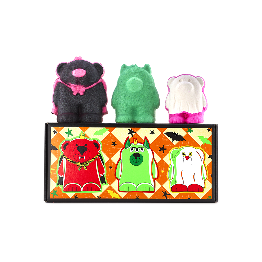Boo Bears gift. Three monster bear bath bombs sit atop an orange chequered box featuring illustrations of themselves. Left to right: a black vampire bear, a green three-eyed monster bear, and a white ghost bear with bright pink feet.