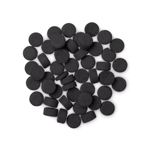 A pile of small, circular, black Boom! toothpaste tabs shot from above.