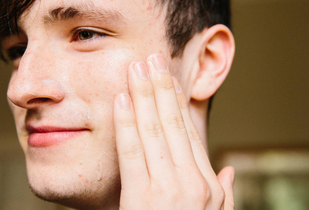 A light layer of smooth, orchid white Cosmetic Lad facial moisturiser is rubbed across one half of a smiling face.