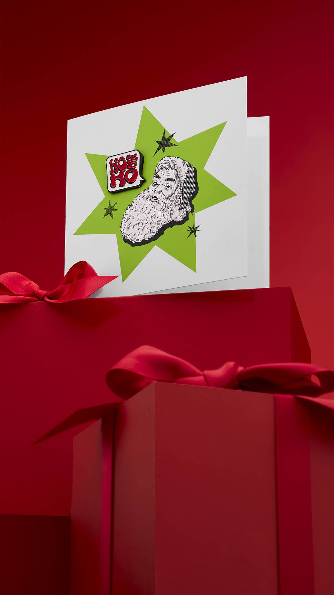 A festive "HO HO HO" greeting card with a comic-style design, featuring a classic black and white illustration of Santa Claus with a green starburst behind him. The card is displayed on a red background with wrapped gifts.