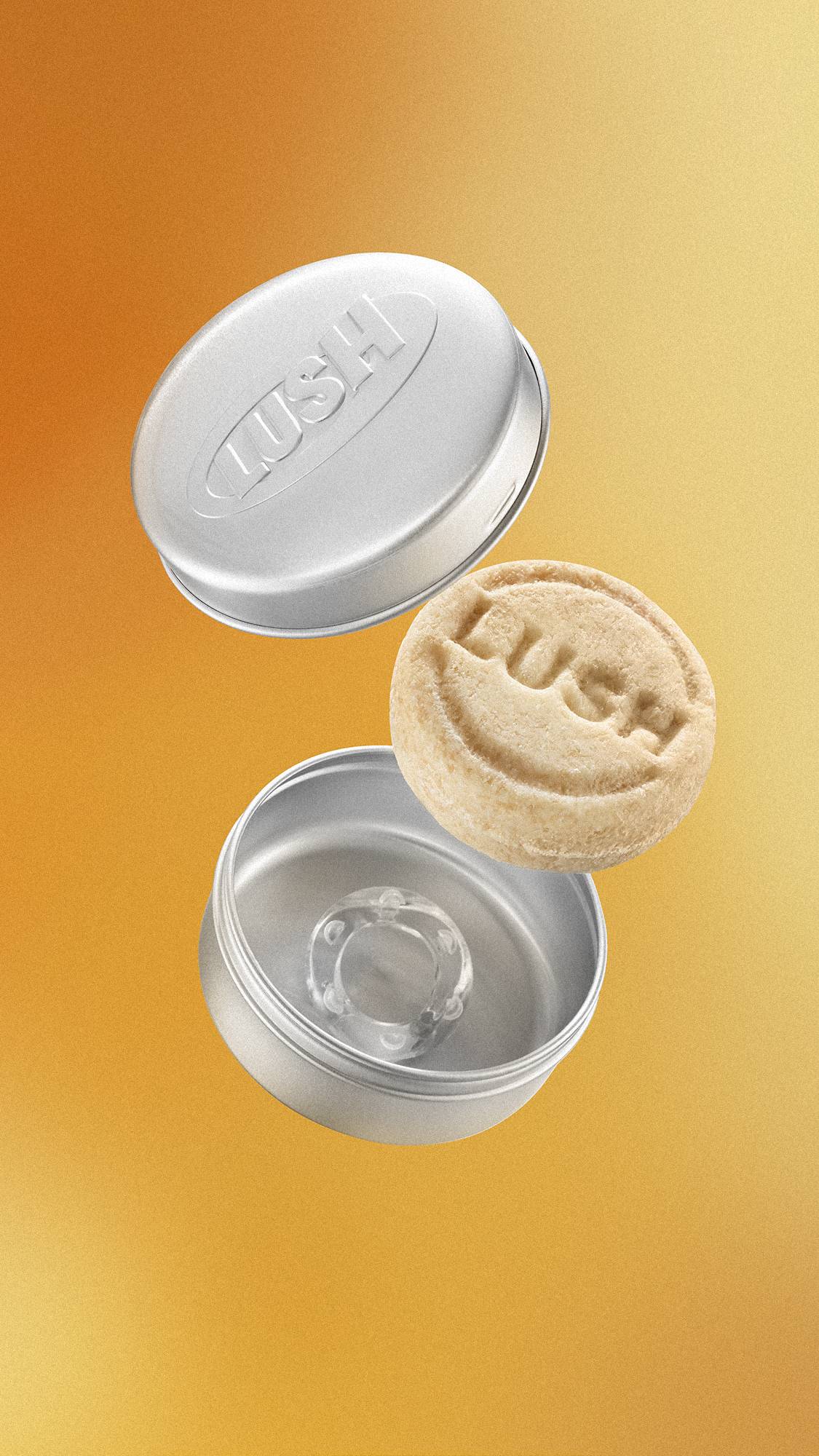 A round, textured beige Lush solid shampoo bar floats mid-air between an open, round silver aluminium tin. The tin lid is embossed with the "LUSH" logo. The background is a soft, metallic gold gradient.