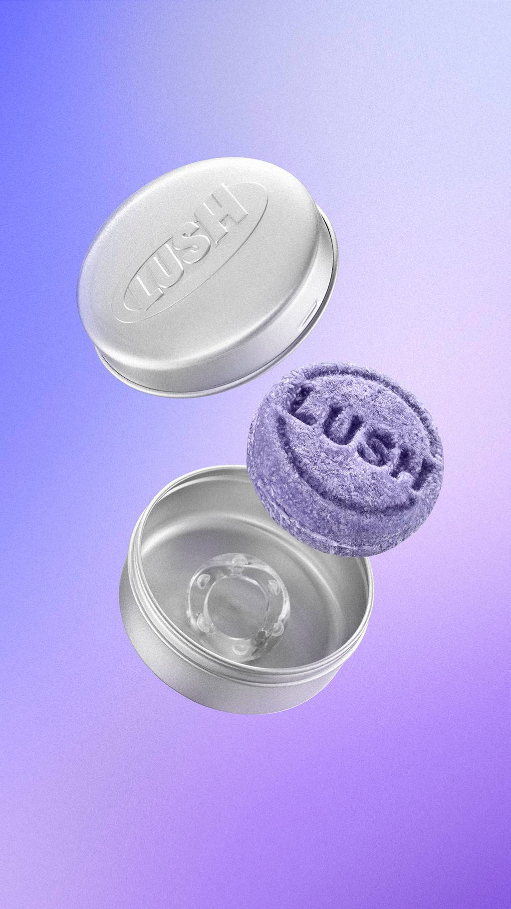 A textured purple Lush shampoo bar floats alongside an open, round silver metal tin with 'LUSH' embossed on the lid. A small clear ring rests inside the base, set against a purple gradient background.