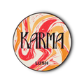 Karma pin badge. A circular metal pin features a swirled pattern of red, orange, and white marbled design. The word 'KARMA' is prominent in black letters, with 'LUSH' below it.