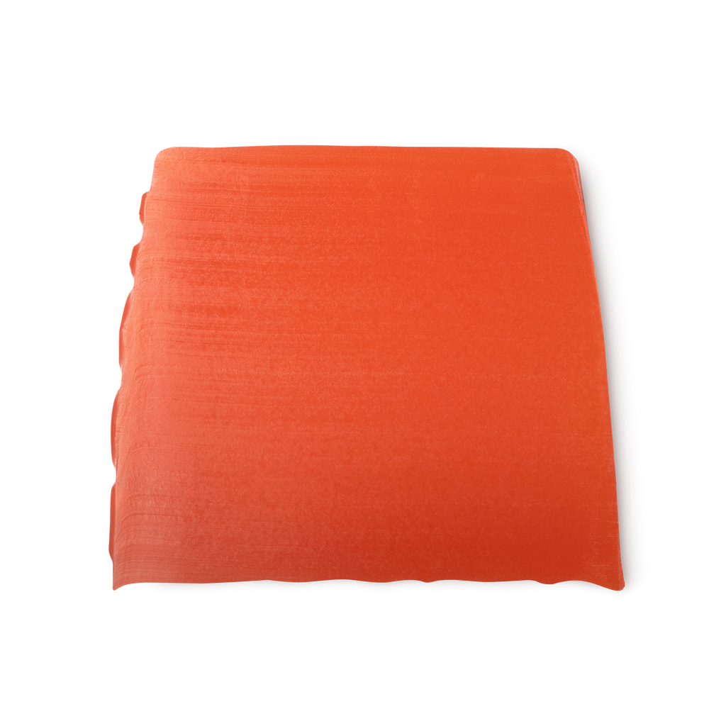 Karma. A deep orange, smooth, trapezium shaped soap, with bumps along its left side.