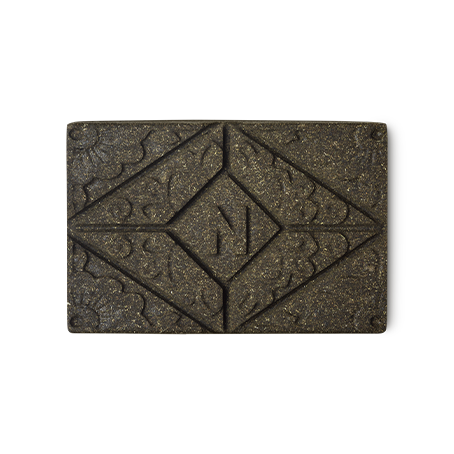 Noir Henna. A brown rectangular block of solid henna hair colour, with a floral design and the letter N pressed on the top.
