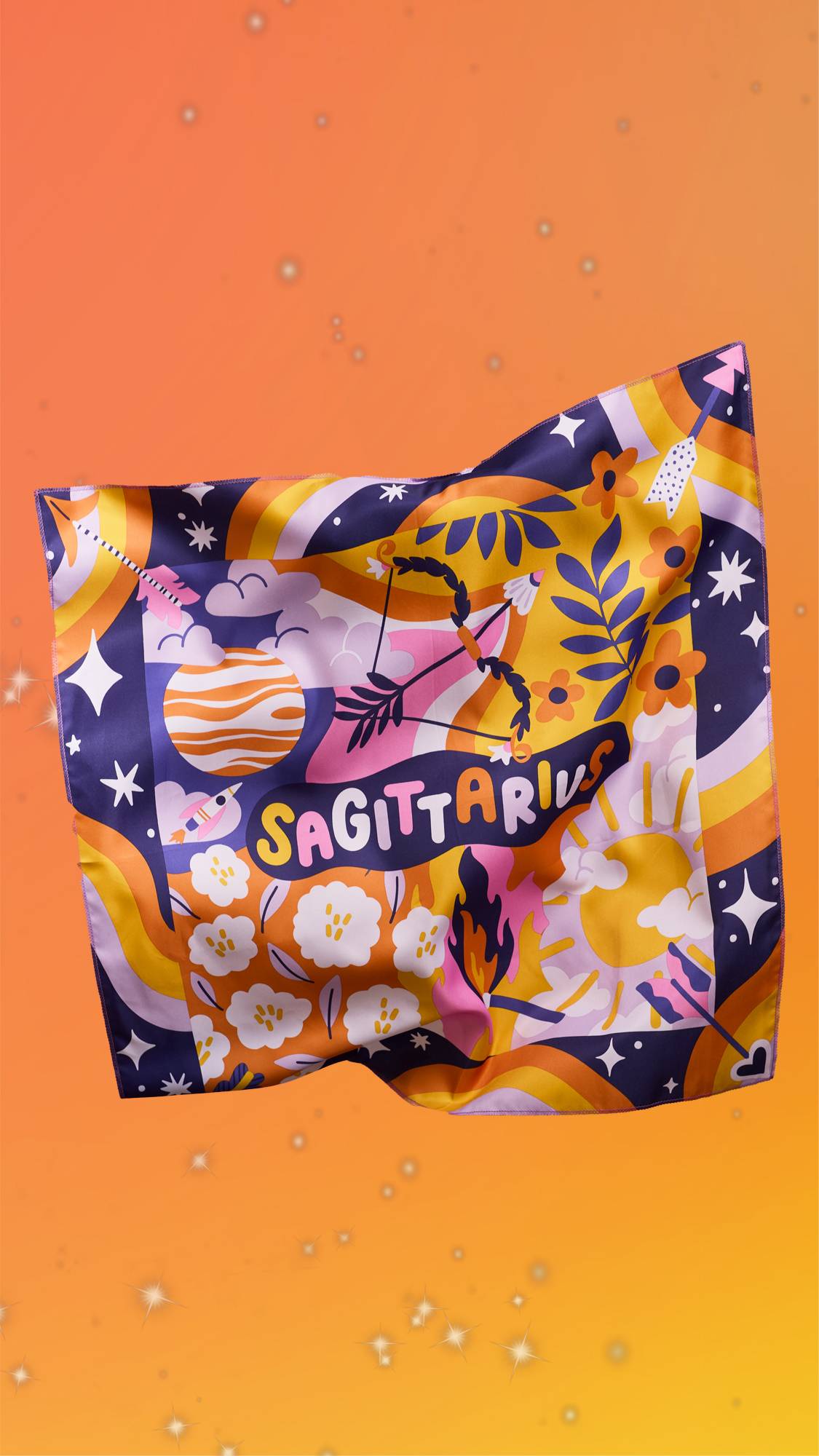 The image shows a yellow and orange blurred background scattered with sparkles. The Sagittarius knot wrap is floating with the design facing the camera showing the shimmering, silky texture of the fabric.