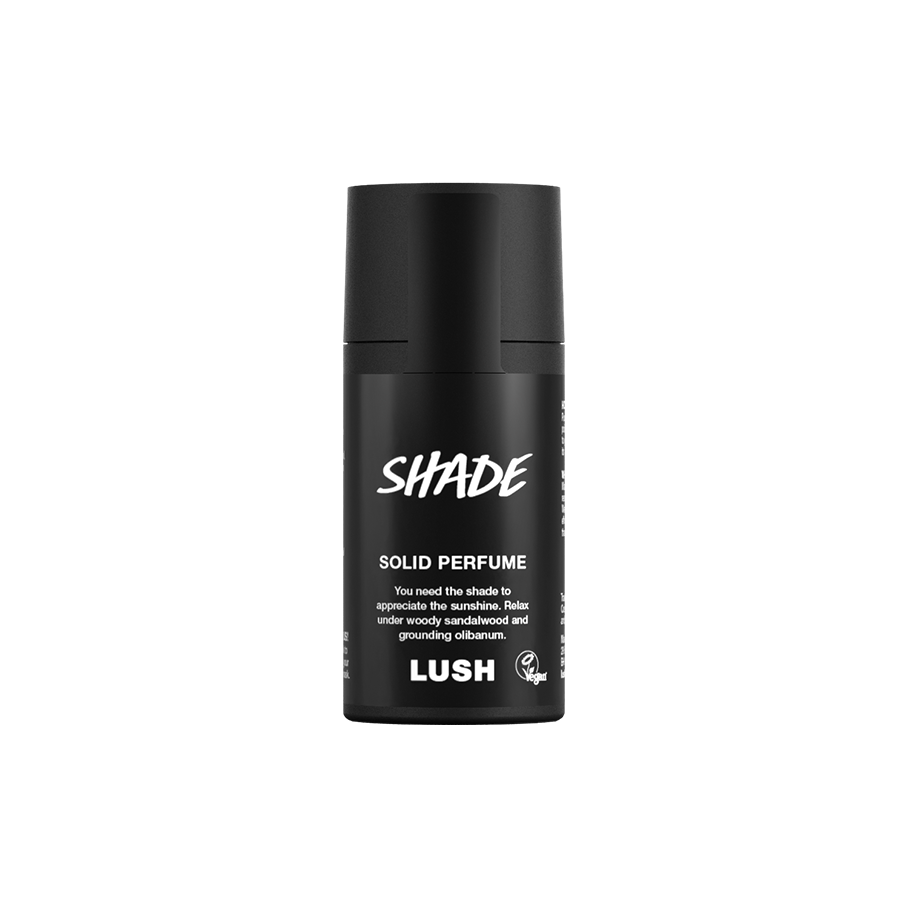 Shade. A short, cylindrical black push-up tube of the Shade solid perfume with a black label on the front covering the cap, with the product name and scent printed on it.