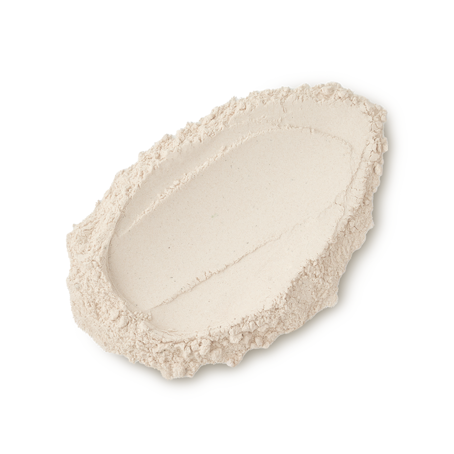 A studio shot of a textured swatch of LUSH Sticky Dates dusting powder, a fine, light beige powder against a light gray background.