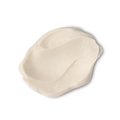A studio shot of a textured swatch of LUSH Supermilk hair conditioner, a pale, off-white product, against a light gray background.