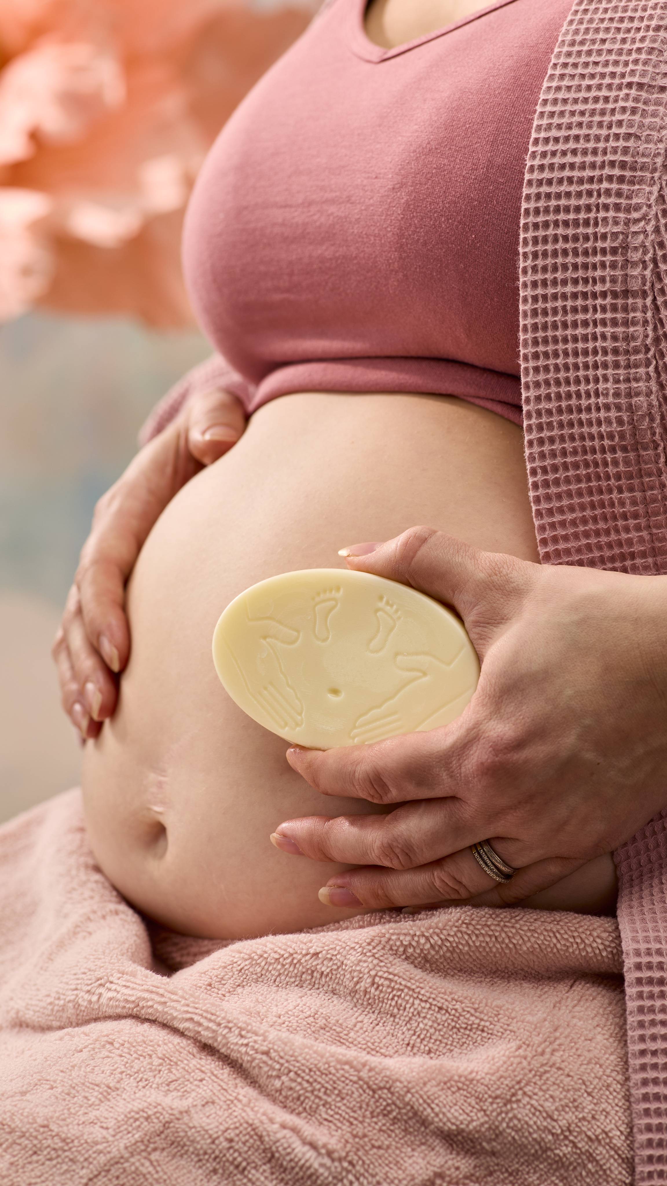 A close-up shot of the model's pregnant belly as they smooth over the moisturising The Bump solid massage bar over this skin.