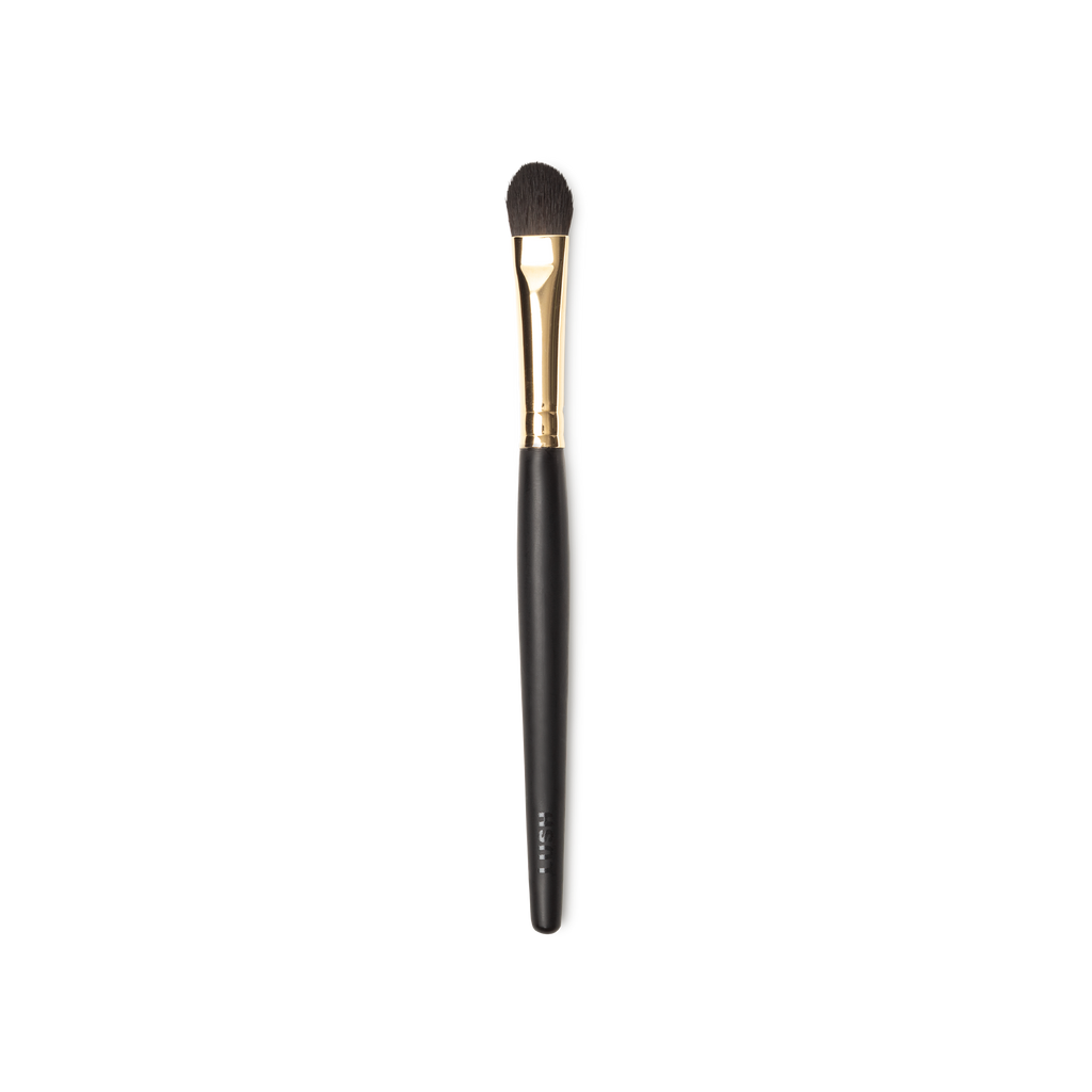 To The Point Brush. A concealer brush, with tapered brown, flat, densley packed bristles. A gold and dark wooden handle.
